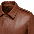 Close-up of a brown leather jacket showing the collar, shoulder, and front stitching against a plain white background.