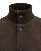 Close-up of a dark brown suede jacket with a ribbed knit mock neck collar and three dark buttons.